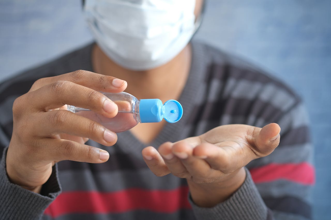 A person applying hand sanitizer to their hands, emphasizing hygiene and safety during the pandemic.